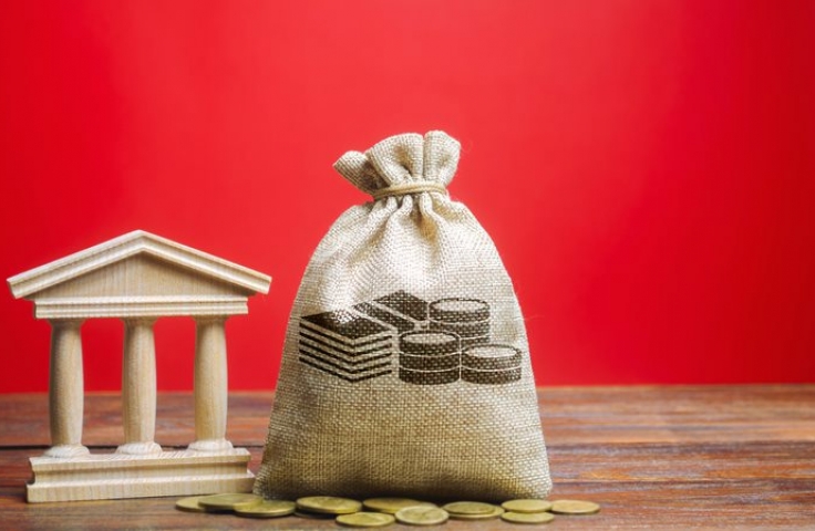 Sack of money in foreground with red background 